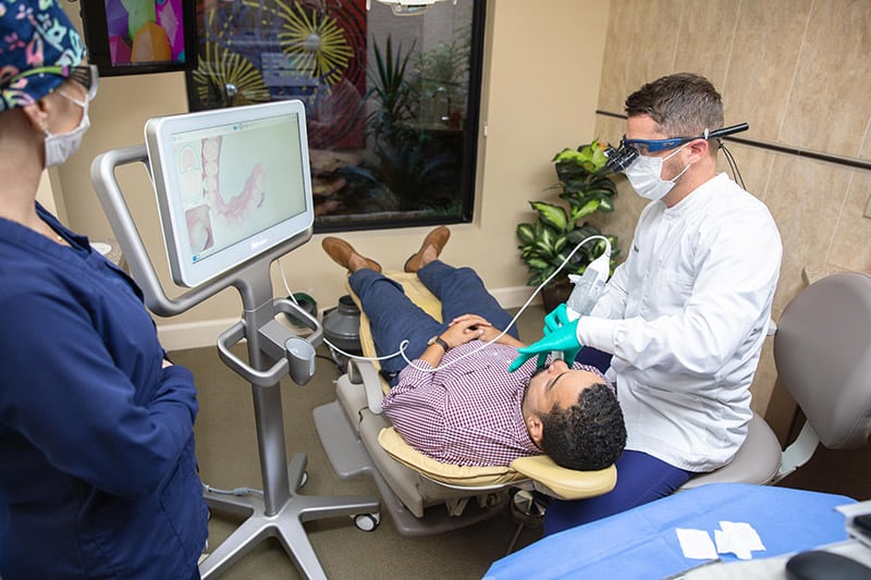 Dr. Phillip Kraver scans patient's teeth to determine what personalized care is needed for the patient