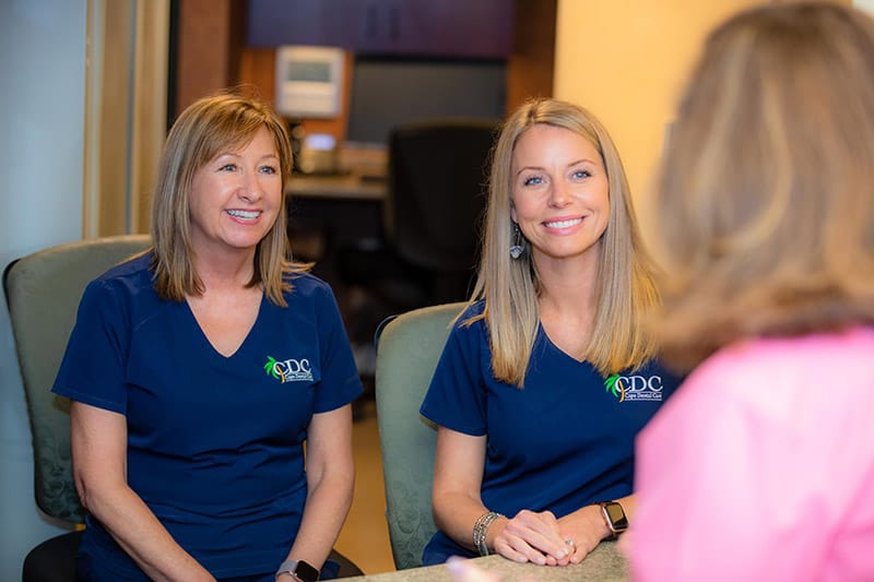 Friendly Cape Dental Care staff smiling as they explain financing options for personalized dental treatments