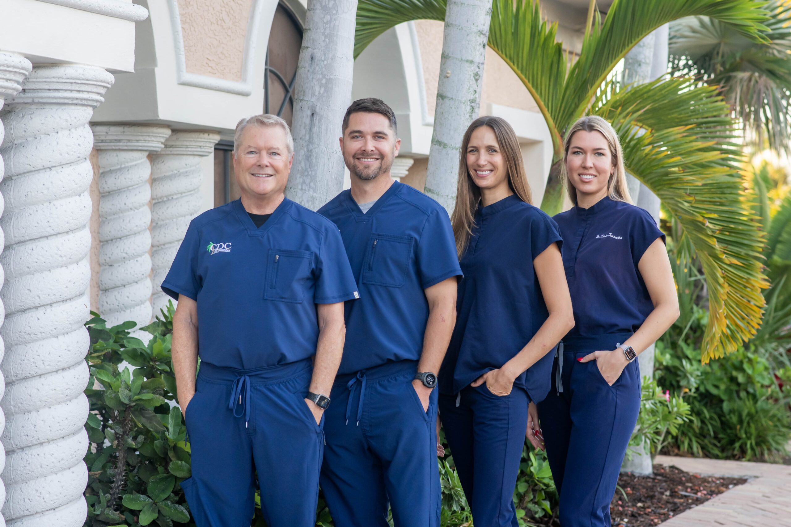 Cape Dental Dentists Dr. Mark Kraver (left), Dr. Phillip Kraver (left middle), Dr. Lindsey Balaban (right middle), and Dr. Linda Kornienko (right) stand in front of their Cape Coral building